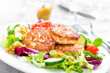 Cutlets and fresh vegetable salad on white plate. Fried meatballs with vegetable salad