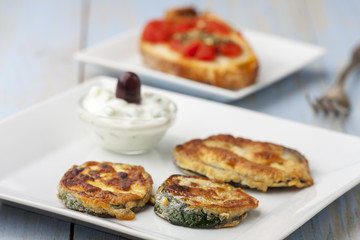 Gebackene Zucchini mit Tsaziki auf Teller