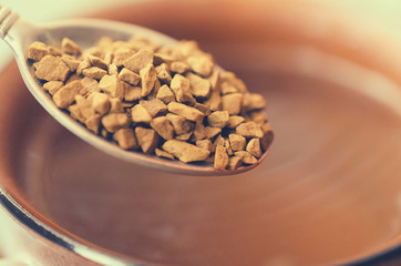 Spoon the granulated coffee into a cup for coffee.