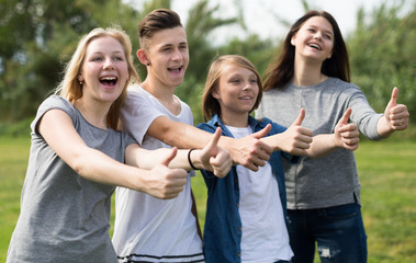teenagers show their thumbs up