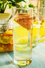 Fototapeta na wymiar A glass of homemade lemonade with a grapefruit on a rustic background