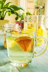 glass of homemade lemonade with a slice of grapefruit on the rustic background