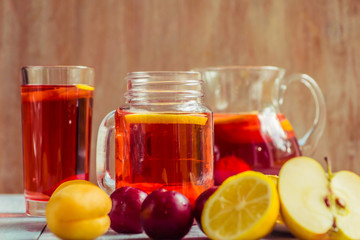 Pink lemonade in a jar with fresh fruit on a rustic wooden background