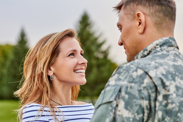 Fototapeta premium Touching moment soldier returning from army. Happy meeting outdoor, lovely gaze, mature couple.