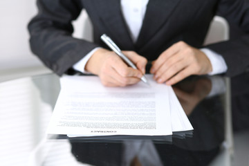Close-up of female hands with pen over document,  business concept