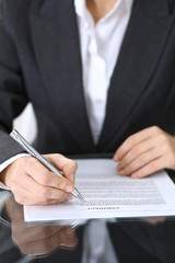 Close-up of female hands with pen over document,  business concept