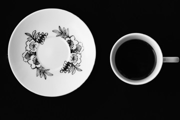 Cup and saucer on a black background stand separately