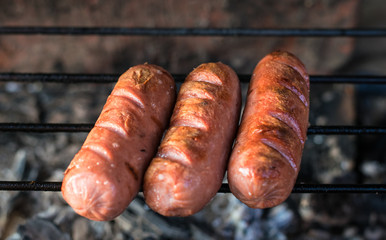 Grilling sausages on barbecue grill. Selective focus.