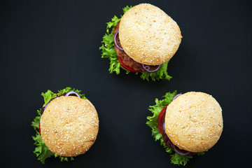 Fresh american burgers on dark background. Top view. Flat lay.