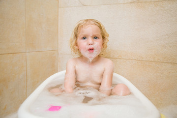 Little cute baby is playing in the bathroom