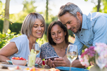 summer. Group of friends gathered around a table in the garden