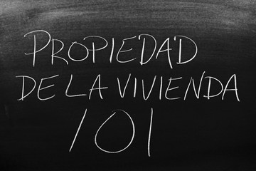 The words Propiedad De La Vivienda 101 on a blackboard in chalk