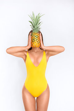Sexy girl in a yellow swimsuit with a pineapple

