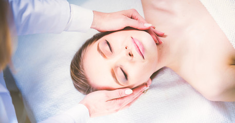 Fototapeta na wymiar Young woman lying on a massage table,relaxing with eyes closed. Woman. Spa salon
