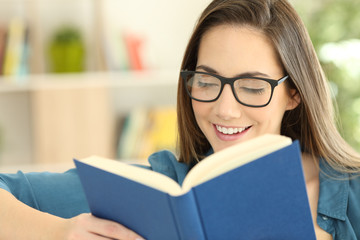 Girl wearing eyeglasses reading a paper book