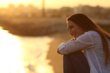 Happy girl contemplating landscape at sunset