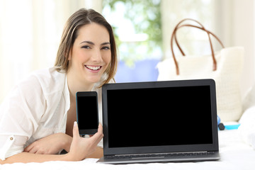 Hotel guest showing blank smartphone and laptop screens