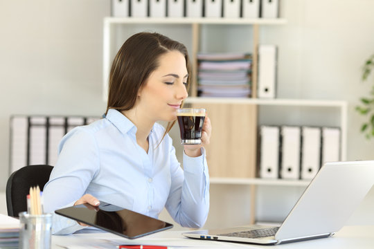 Office worker relaxing smelling coffee