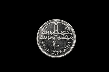 A macro image of a ten piastre coin from Egypt isolated on a black background