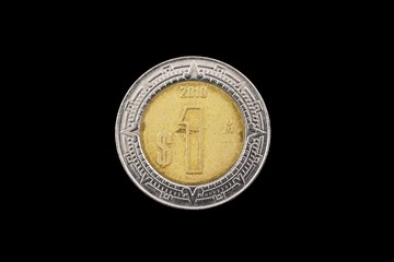 A macro image of a Mexican one peso isolated on a black background