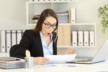 Amazed office worker reading sales report