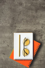 Top view close up of spectacles and office incidentals locating on notebook. Creative concept