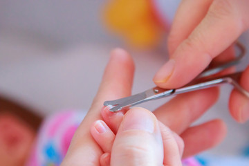 cutting newborn baby nails with scissors close