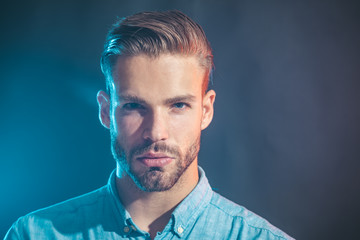 Emotions, feelings, facial expressions concept - serious fashionable bearded man. Sexy handsome unshaven man in denim shirt. Sexy male model thinking on something. Attractive man in casual clothing.