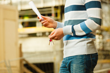 Young man carrying keyring with documents.