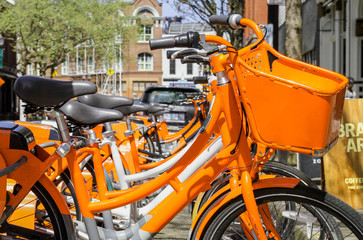 Fototapeta na wymiar Orange Bicycle Rental Kiosk in the City