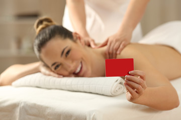 Obraz na płótnie Canvas Woman receiving a massage showing credit card