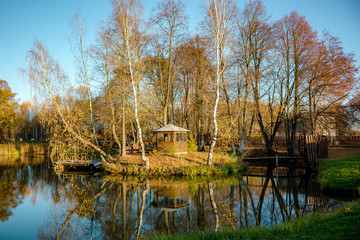 Beautiful pond with a little island and a garden house in the evening
