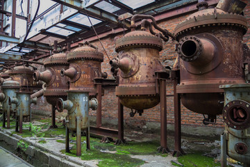 Old rusty industrial containers in abandoned chemical factory