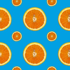 Creative pattern made of orange on blue background. Food concept.