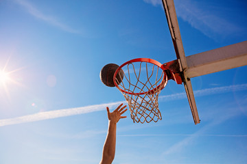 Slam Dunk. Side view of young basketball player making slam dunk