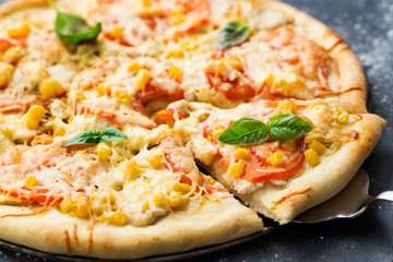 Pizza with chicken meat pieces, tomatoes, corn and cheese on a dark background. Healthy food