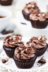 Chocolate cupcakes decorated coffee cheese cream on a white plate