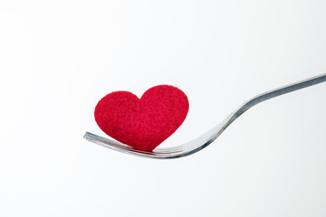 the red heart shape in silver fork , romance love dinning or health heart care concept