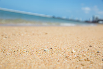 Focus of the sand on the beach with blur background of blue sea