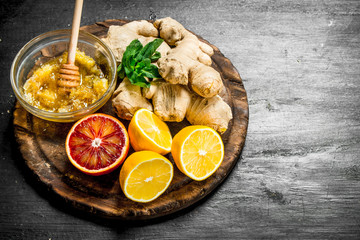 Fresh ginger with honey and lemons on the Board.