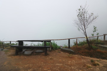 Fototapeta na wymiar Wooden bench with heavy fog on the sky.