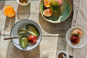 Top view set of various fruits with nuts and carrot juice on wooden table, flat lay. Rustic style, healthy food concept