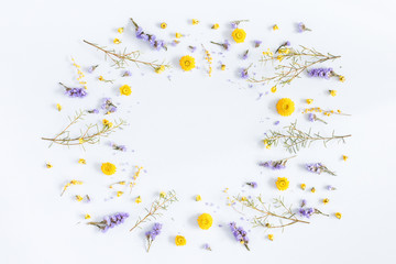Flowers composition. Frame made of yellow and purple flowers on pastel blue background. Flat lay, top view, copy space