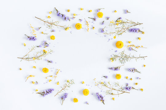 Flowers composition. Frame made of yellow and purple flowers on pastel blue background. Flat lay, top view, copy space
