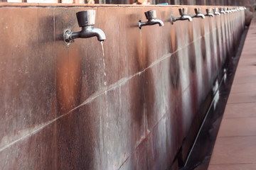 many steel taps with drinking water flowing