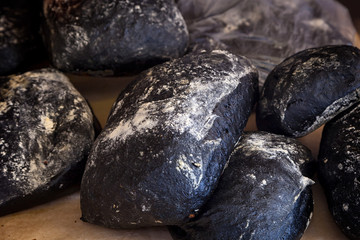 Close-up of fresh black bread in buns in a bakery, fresh loaves, ciabatta