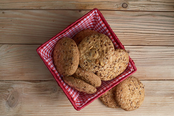 homemade oat cookies with sunflower seeds in basket on wooden table