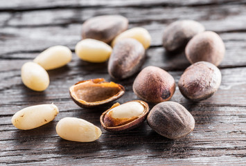Pine nuts on dark wooden table. Organic food. Macro.