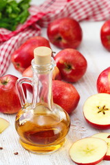 Apple vinegar. Bottle of apple vinegar on wooden background.