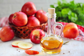 Apple vinegar. Bottle of apple vinegar on wooden background.